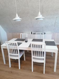 a white table and chairs in a room at Norderbarg in Bredstedt
