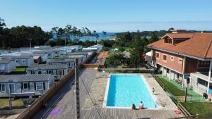 an aerial view of a swimming pool with houses at Somo Bungalow Resort - Camping Latas in Somo +65 photos