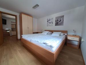 1 dormitorio con 1 cama grande y suelo de madera en Apartments Pr'Krštano, en Kranjska Gora