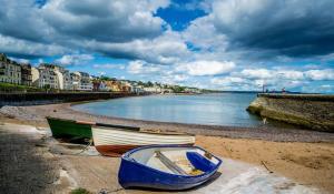 two boats sitting on the shore of a beach at Dawlish Lawn View in Dawlish