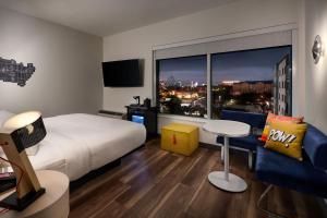 a hotel room with a bed and a large window at Aloft Orlando International Drive in Orlando