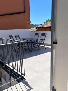 a patio with a table and chairs on a balcony at Residenza Orchidee in Costermano