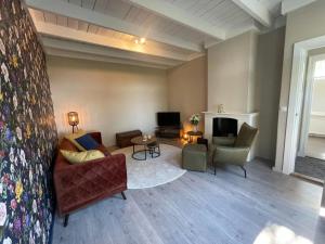 a living room with a couch and chairs and a tv at Vacation home in Schoonloo with terrace in Schoonloo
