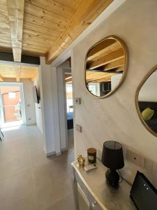 Habitación con mesa, lámpara y espejo. en Residenza Orchidee, en Costermano