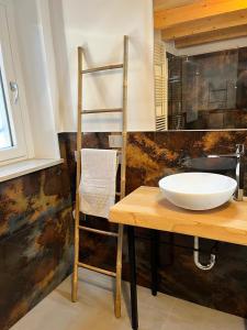 un baño con lavabo y una mesa de madera con una escalera. en Residenza Orchidee, en Costermano