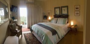 1 dormitorio con 1 cama con ventana y 2 lámparas en Llarrinda Bed & Breakfast, en Foster