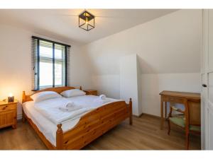 - une chambre avec un lit en bois et un bureau dans l'établissement characteristic house in a rural location in the village of Zuidzande with garden, à Zuidzande
