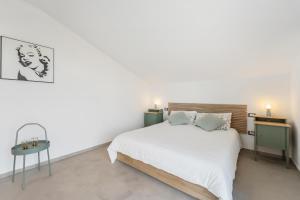 a white bedroom with a bed and a table at La Pimpinella in Su Forti
