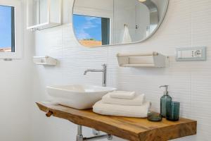 a bathroom with a sink and a mirror at La Pimpinella in Su Forti +13 photos