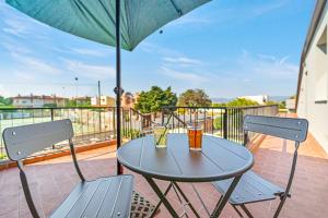 a table with two drinks on a balcony with an umbrella at La Pimpinella in Su Forti