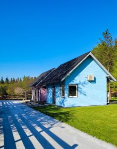 een blauw huis met een zwart dak en gras bij Letnisko Stróżówka 