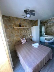 ein Schlafzimmer mit einem Bett und einer Steinmauer in der Unterkunft Casita en el Tajo in Setenil de las Bodegas