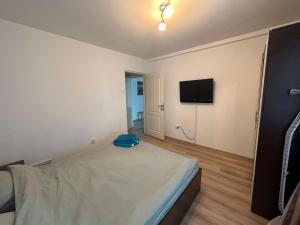a bedroom with a bed and a flat screen tv at Cozy Neversea Apartament in Constanţa