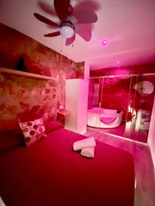 a bedroom with a red bed and a ceiling fan at Casita en el Tajo in Setenil