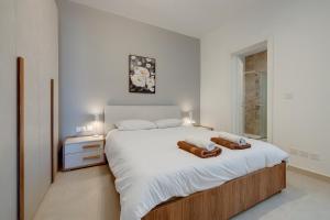 a bedroom with a large bed with two towels on it at Luxury Maisonette in a Tranquil and Central Area in St Julian's