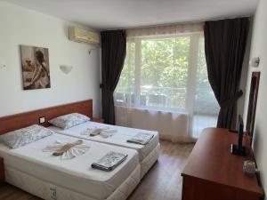 ein Hotelzimmer mit 2 Betten und einem Fenster in der Unterkunft Complex Nev in Burgas City