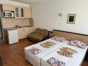 a hotel room with two beds and a kitchen at Complex Nev in Burgas