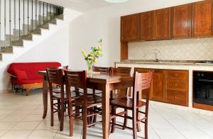 a kitchen with a wooden table and chairs at Villetta Maldive Salento in Torre Vado