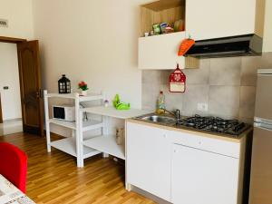 マルサラにあるCasa vacanze Misillaの白いキャビネットとシンク付きのキッチン