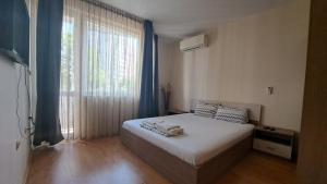 a bedroom with a bed and a large window at Luxury Apartment VLADISLAV in Varna City