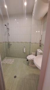 a bathroom with a shower and a toilet and a sink at Luxury Apartment VLADISLAV in Varna City