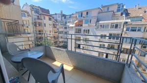 a balcony with chairs and tables and buildings at Luxury Apartment VLADISLAV in Varna City