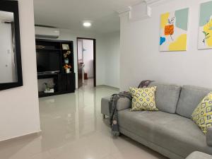 sala de estar con sofá y TV en Habitación en apartamento compartido al frente del cc Unico, en Barranquilla