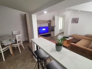 una cucina e un soggiorno con tavolo e sedie di Podinario a Soko Banja