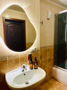 W łazience znajduje się umywalka i lustro. w obiekcie Hotel DENINNA w mieście Winnica