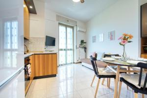 una cucina e un soggiorno con tavolo e sedie di CaseOspitali - Casa Graziella a 5 min dal San Raffaele a Milano
