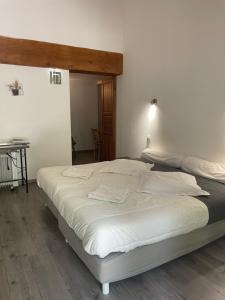 a bedroom with two beds and a table in it at Domaine Les Cascades in Ribaute