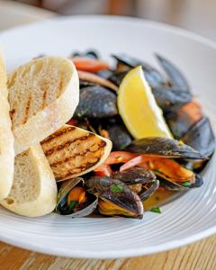 a plate of food with mussels and a slice of lemon at The Randolph Hotel in Southwold