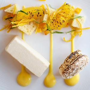 a plate of food with yellow spoons and flowers at The Randolph Hotel in Southwold