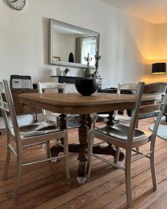 mesa de comedor con sillas y espejo en Chez La Vieille Dame, en Cosne-Cours-sur-Loire