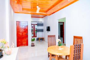 a dining room with a table and a red door at Thisha Hotel in Jaffna
