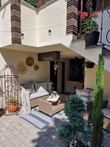 a patio with a couch and a bird cage at Kamelia guest rooms in Kazanlŭk
