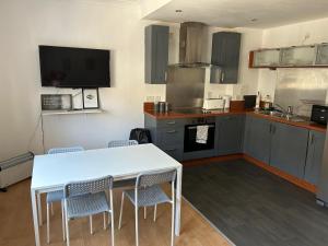 a kitchen with a white table and chairs in it at Apex Variety Gate Apartment in Glasgow