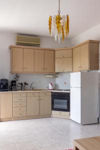a kitchen with wooden cabinets and a white refrigerator at Spacious seaside house in Nea Potidaea