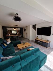 a living room with a green couch and a tv at Villa Porta Krk in Krk