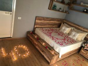 a bedroom with a large wooden bed with lights on it at Guesthouse "Gjin Thana" in Theth