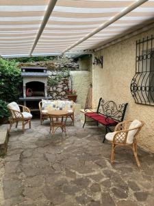 un patio con sillas, mesa y chimenea en Le Terrazze di Gio en Sennori