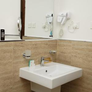 a bathroom with a white sink and a mirror at Kara Hotel فندق كارا in Al Khobar