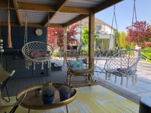 a patio with two chairs and a table and a swing at Witte Merel Glamping in Beringen