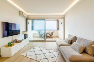 un soggiorno con un divano e una televisione di Brises Marines par Dodo-à-Cassis a Cassis