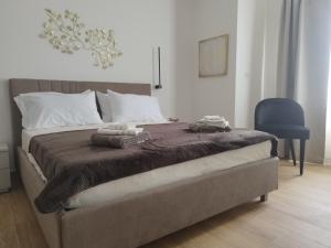 una camera da letto con un letto e due asciugamani di Coral Reef Apartments a San Pawl il-Baħar