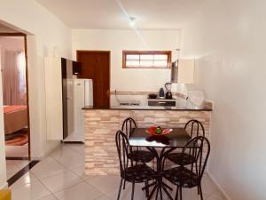 uma cozinha com mesa e cadeiras num quarto em Casas Aconchegantes Temporada em Cabo Frio