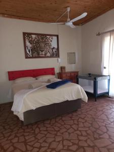 a bedroom with a large bed and a table at Thekwane Holiday House in Klipdrift