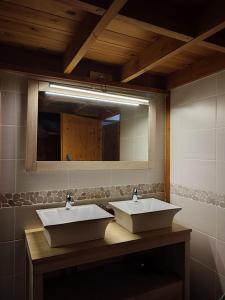 a bathroom with two sinks and a mirror at Domaine Les Cascades in Ribaute