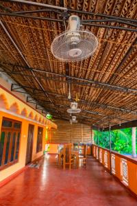 een kamer met tafels en stoelen en een plafond bij Thisha Hotel in Jaffna