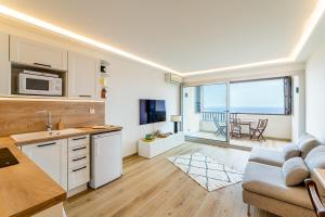 una cucina e un soggiorno con un divano e un tavolo di Brises Marines par Dodo-à-Cassis a Cassis